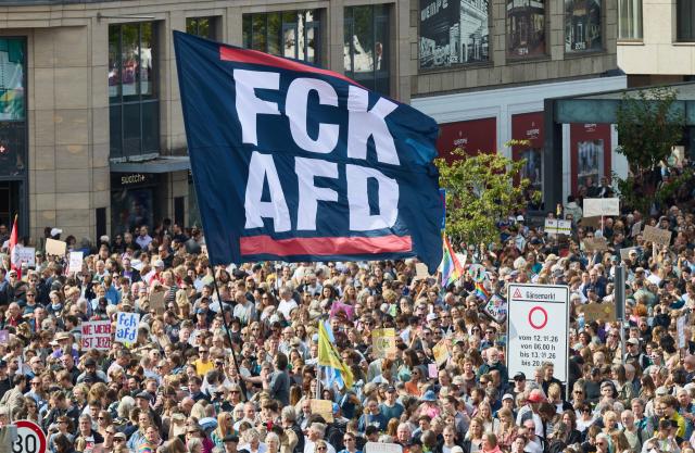 12 September 2026, Hamburg: A person holds a flag on Jungfernstieg that reads "FCK AfD" during the coalition demonstration against right-wing extremism and for democratic cohesion following the state election in Saxony-Anhalt. Photo: Georg Wendt/dpa