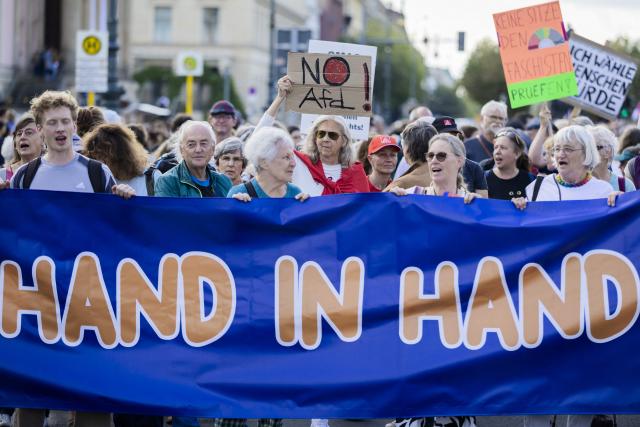 12 September 2026, Berlin: People carry a banner reading "Hand in Hand" during a march in support of social cohesion from Unter den Linden to the Rotes Rathaus-one under the slogan "Time for a Change". Photo: Christoph Soeder/dpa