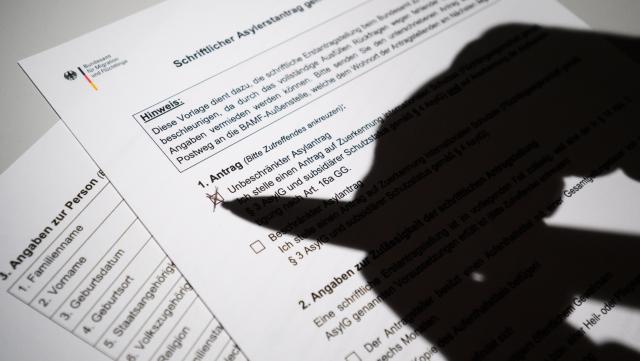 FILED - 08 June 2023, Lower Saxony, Hanover: FILE PHOTO - A person fills an asylum application of the German Federal Office for Migration and Refugees (BAMF). Photo: Julian Stratenschulte/dpa