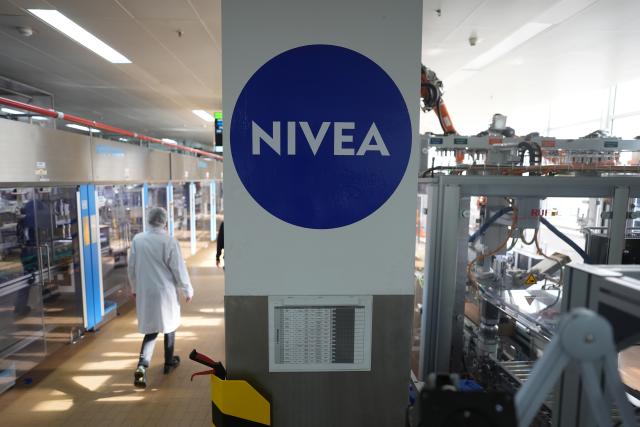 FILED - 25 February 2025, Hamburg: FILE PHOTO - An employee walks through a Nivea Creme production hall at Beiersdorf Manufacturing Hamburg. Photo: Marcus Brandt/dpa