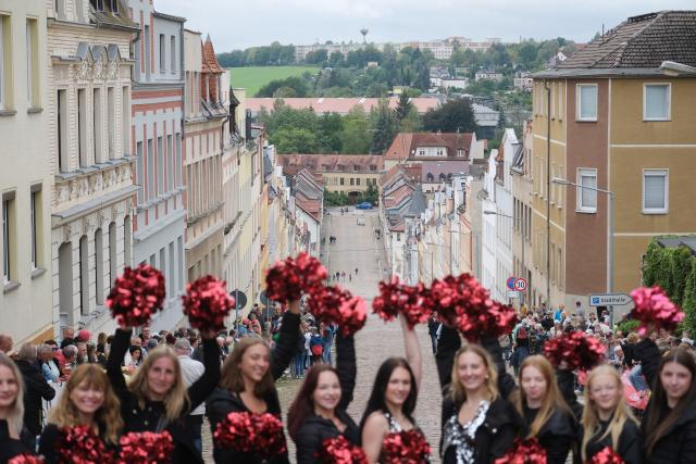13 September 2026, Saxony, Meerane: Cheerleaders line up at the top of the "Steile Wand" on the occasion of the arrival of the cyclists from the European Peace Ride, a bike race with about 200 participants. Photo: Sebastian Willnow/ dpa/dpa