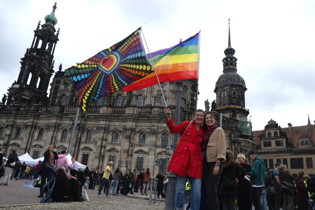13 September 2026, Saxony, Dresden: Two female participants hold rainbow-colored flags at a demonstration on Theaterplatz, under the slogan "Time to Act" in response to the state election in Saxony-Anhalt. Photo: Katharina Kausche/dpa