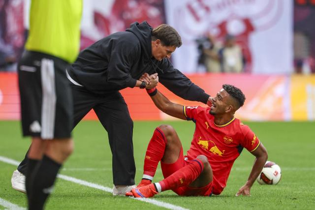 13 September 2026, Saxony, Leipzig: Hamburger coach Merlin Polzin helps Leipzig's Benjamin Henrichs during the German Bundesliga soccer match between RB Leipzig and Hamburger SV at Red Bull Arena. Photo: Jan Woitas/dpa - IMPORTANT NOTICE: In accordance with the regulations of the Bundesliga and the DFB (German Football Association), it is prohibited to use or allow the use of photographs taken in the stadium and/or during the game in the form of sequential images and/or video-like photo sequences.