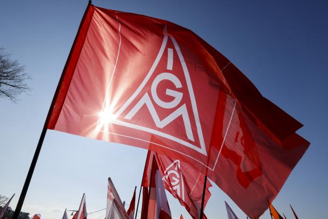 FILED - 15 March 2025, North Rhine-Westphalia, Cologne: FILE PHOTO - Participants hold up flags bearing the IG Metall logo during a demonstration in Cologne. Photo: Thomas Banneyer/dpa