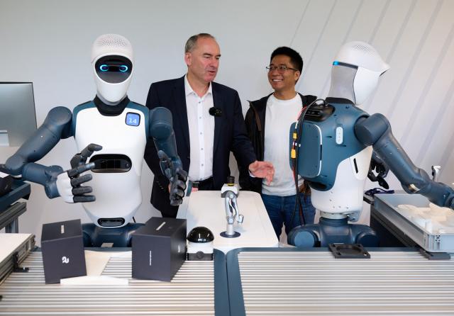 14 September 2026, Bavaria, Munich: Bavaria's Minister of Economic Affairs, and Zhaopeng Chen (R), founder and CEO of Agile Robots, stand next to the humanoid robot "Agile ONE" during a press event at Agile Robots' corporate headquarters. Photo: Sven Hoppe/dpa