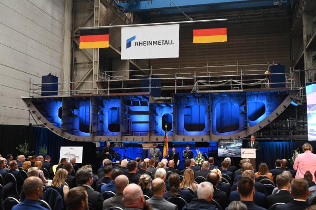 14 September 2026, Mecklenburg-Western Pomerania, Wolgast: German Defense Minister Boris Pistorius (back row, R) speaks at the keel-laying ceremony for the third Class 424 fleet support vessel, in the Peene Shipyard's assembly hall. Rheinmetall's Naval Systems division is responsible for the production of the latest generation of reconnaissance vessels, carried out at the Wolgast and Hamburg sites. Photo: Stefan Sauer/dpa