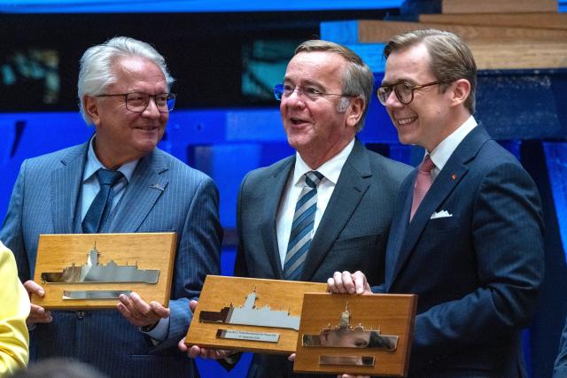 14 September 2026, Mecklenburg-Western Pomerania, Wolgast: German Defense Minister Boris Pistorius (C) holds a commemorative plaque during the keel-laying ceremony for the third Class 424 fleet service vessel at the Peene Shipyard. Standing next to him are Philipp Amthor (R), Minister of State for Federal-State Relations at the Federal Chancellery, and Armin Papperger, CEO of the defense contractor Rheinmetall. Photo: Stefan Sauer/dpa