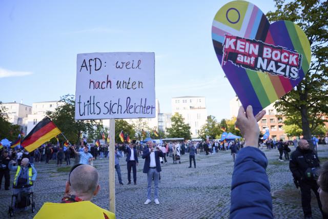 14 September 2026, Berlin: Demonstrators hold signs reading "AfD, because it's easier to kick down" and "No way with Nazis" in German during the counter-demonstration against the Alternative for Germany (AfD) rally on Hugenottenplatz. Photo: Annette Riedl/dpa