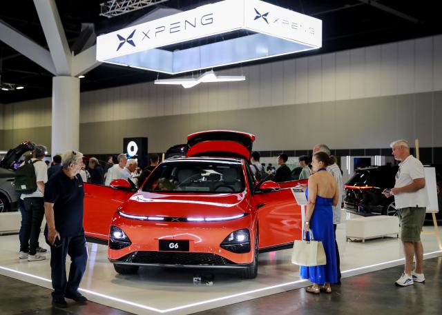 (241108) -- SYDNEY, Nov. 8, 2024 (Xinhua) -- Audience look at XPENG G6 during the Sydney International EV AutoShow 2024 in Sydney, Australia, Nov. 8, 2024. The three-day event kicked off at the International Convention & Exhibition Center in Sydney on Friday, showcasing electric vehicles from global manufacturers. (Xinhua/Ma Ping)