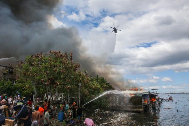 (241124) -- MANILA, Nov. 24, 2024 (Xinhua) -- A helicopter from the Philippine Air Force drops water to put out a fire engulfing a slum area in Manila, the Philippines on Nov. 24, 2024. (Xinhua/Rouelle Umali)