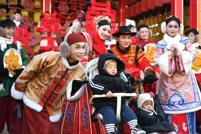 (241126) -- YINCHUAN, Nov. 26, 2024 (Xinhua) -- Tourists pose for photos with performers at an immersive performing arts town in Xixia District of Yinchuan, northwest China's Ningxia Hui Autonomous Region, Nov. 25, 2024.
  The immersive performing arts town, also called Manpu Town, is a tourism resort attracting people with its unique Helan Mountain culture. (Xinhua/Mao Zhu)