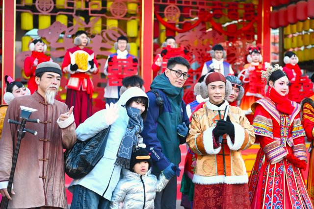 (241126) -- YINCHUAN, Nov. 26, 2024 (Xinhua) -- Tourists pose for photos with performers at an immersive performing arts town in Xixia District of Yinchuan, northwest China's Ningxia Hui Autonomous Region, Nov. 25, 2024.
  The immersive performing arts town, also called Manpu Town, is a tourism resort attracting people with its unique Helan Mountain culture. (Xinhua/Mao Zhu)