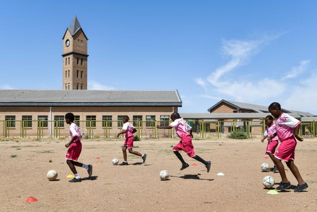 (241126) -- KWENENG, Nov. 26, 2024 (Xinhua) -- Students play football at China-aided Mmopane Primary School in Mmopane, Kweneng District, Botswana, Nov. 4, 2024. Mmopane Primary School, which opened in 2021, is one of the four primary schools in Botswana built with a grant from the Chinese government, the other three being Kubung Primary School, Dinokwane Primary School, and Ramaeba Primary School. These China-aided schools feature computer labs, science labs, libraries, dining halls, disability-friendly facilities, and football and basketball fields. (Xinhua/Han Xu)