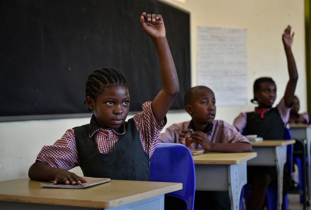 (241126) -- KWENENG, Nov. 26, 2024 (Xinhua) -- Pradence Tshepi (L) attends a class at China-aided Mmopane Primary School in Mmopane, Kweneng District, Botswana, Nov. 4, 2024. Mmopane Primary School, which opened in 2021, is one of the four primary schools in Botswana built with a grant from the Chinese government, the other three being Kubung Primary School, Dinokwane Primary School, and Ramaeba Primary School. These China-aided schools feature computer labs, science labs, libraries, dining halls, disability-friendly facilities, and football and basketball fields. (Xinhua/Han Xu)