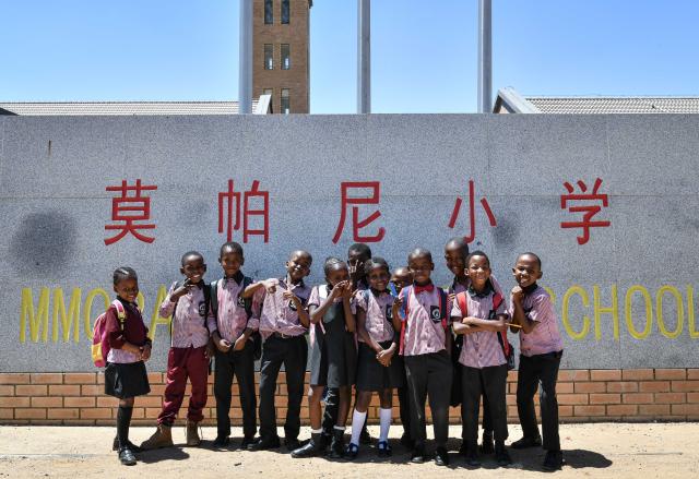 (241126) -- KWENENG, Nov. 26, 2024 (Xinhua) -- Students pose for a group photo at the gate of China-aided Mmopane Primary School in Mmopane, Kweneng District, Botswana, Nov. 4, 2024. Mmopane Primary School, which opened in 2021, is one of the four primary schools in Botswana built with a grant from the Chinese government, the other three being Kubung Primary School, Dinokwane Primary School, and Ramaeba Primary School. These China-aided schools feature computer labs, science labs, libraries, dining halls, disability-friendly facilities, and football and basketball fields. (Xinhua/Han Xu)