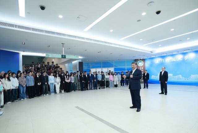 (241219) -- MACAO, Dec. 19, 2024 (Xinhua) -- Chinese President Xi Jinping, also general secretary of the Communist Party of China Central Committee and chairman of the Central Military Commission, talks with teachers, students and scientific researchers in the library of Macau University of Science and Technology (MUST) in south China's Macao, Dec. 19, 2024. Xi, accompanied by Ho Iat Seng, chief executive of the Macao Special Administrative Region (SAR), visited the university Thursday morning. (Xinhua/Ju Peng)