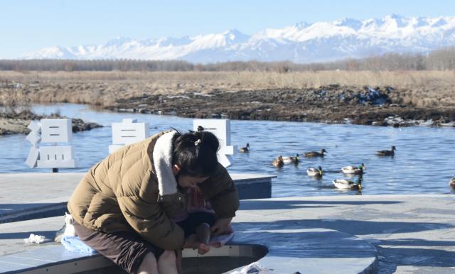 (241221) -- WENQUAN, Dec. 21, 2024 (Xinhua) -- Kulmkhan Bagatur and her daughter soak their feet in the soothing warmth of a natural hot spring in Wenquan County, northwest China's Xinjiang Uygur Autonomous Region, Nov. 28, 2024. TO GO WITH "Wondrous Xinjiang: Hot springs spread warmth among locals, tourists" (Xinhua/Zhang Xiaolong)