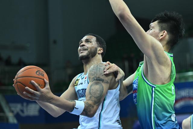 (241221) -- TIANJIN, Dec. 21, 2024 (Xinhua) -- Quinndary Weatherspoon (L) of Qingdao Eagles goes to the basket during a match between Tianjin Pioneers and Qingdao Eagles at the 2024-2025 season of the Chinese Basketball Association (CBA) league in Tianjin, China, Dec. 21, 2024. (Xinhua/Sun Fanyue)