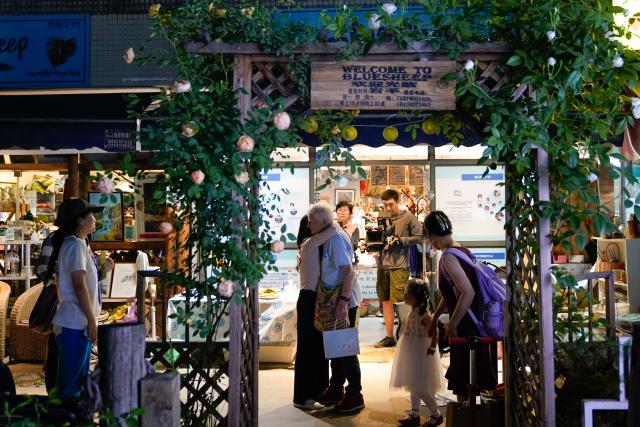 (250509) -- CHENGDU, May 9, 2025 (Xinhua) -- Rachel Grace Pinniger (4th L) bids farewell to her friend in front of Blue Sheep, a handicrafts shop, in Chengdu, southwest China's Sichuan Province, April 19, 2025. TO GO WITH "Profile: British octogenarian's journey from healing hands to helping hearts" (Xinhua/Xu Bingjie)