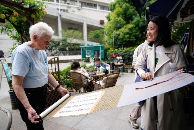 (250509) -- CHENGDU, May 9, 2025 (Xinhua) -- A supporter of the handicrafts shop Blue Sheep (R) offers a calligraphy work of hers as a farewell gift to Rachel Grace Pinniger (L) in Chengdu, southwest China's Sichuan Province, April 11, 2025.
  All eyes were on the beloved Rachel Grace Pinniger, nicknamed "Grandma Rachel," at a farewell event held in front of Blue Sheep in April. 
  Rachel, 79, a native to England, has traversed conflict zones and disaster-hit areas after graduation from medical school to pursue a career of medical, healthcare and education services in more than a dozen of developing countries across Asia and Africa.
  Rachel rushed to Sichuan in 2008, and devoted herself wholeheartedly to the Wenchuan earthquake relief efforts, and kept thinking how she could help more. In 2013, Rachel moved to Chengdu and founded the handicrafts shop Blue Sheep, named after the Himalayan mountain goats that thrive in the plateau's harsh natural environment. 
   The shop deals handicrafts made by disabled artisans and struggling families. Over the past decade, the shop has supported more than 1,000 disadvantaged individuals in Sichuan.
  Before her 80th birthday, Rachel decided to leave Chengdu and return to her hometown with precious memories. At the farewell event held by Blue Sheep's staff and volunteers, she said she would continue to care for those in need, and encourage the loving ones to keep their support for Blue Sheep and the artisans who craft hope with their deft fingers and steadfast minds. (Xinhua/Xu Bingjie)