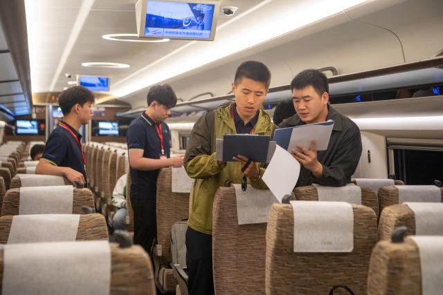 (250509) -- CHONGQING, May 9, 2025 (Xinhua) -- Railway staff wait for the departure inside the high-speed test train in southwest China's Chongqing Municipality, May 9, 2025. With the departure of the high-speed test train from Chongqing East Railway Station, the joint debugging and test of Chongqing section of the newly-built Chongqing-Xiamen high-speed railway were successfully completed and started its test operation on Friday. (Xinhua/Tang Yi)