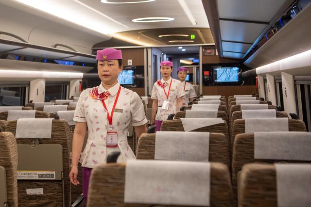 (250509) -- CHONGQING, May 9, 2025 (Xinhua) -- Railway staff wait for the departure inside the high-speed test train in southwest China's Chongqing Municipality, May 9, 2025. With the departure of the high-speed test train from Chongqing East Railway Station, the joint debugging and test of Chongqing section of the newly-built Chongqing-Xiamen high-speed railway were successfully completed and started its test operation on Friday. (Xinhua/Tang Yi)