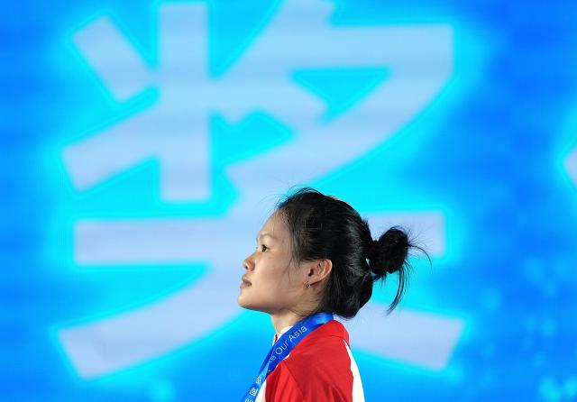 (250509) -- JIANGSHAN, May 9, 2025 (Xinhua) -- Zhao Jinhong of China reacts during the awarding ceremony for the women's 45kg competition at 2025 Asian Weightlifting Championships in Jiangshan, east China's Zhejiang Province, May 9, 2025. (Xinhua/Hou Zhaokang)