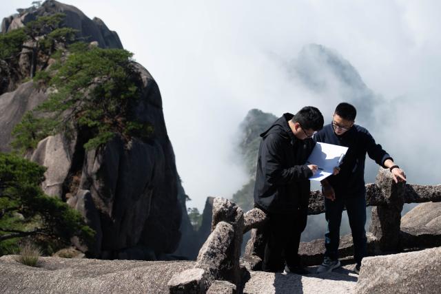 (250509) -- HUANGSHAN, May 9, 2025 (Xinhua) -- Staff workers of Huangshan Scenic Area Yu Yangyang and Sheng Zeyang (L) conduct inspection on historical stone carvings at Lianhua Peak of Huangshan in east China's Anhui Province, on April 23, 2025. Huangshan Mountain is a listed UNESCO World Cultural and Natural Heritage Site, which has attracted a large number of tourists.
  To minimize the impact of visitors on its vegetation growth, the Huangshan Scenic Area rotates days off for its major scenic spots, as a special arrangement for ecological protection.
   The Tiandu Peak, one of the most popular sites in the Huangshan scenic area, ended its more than five-year "vacation" and resumed opening to the public on May 20, 2024. While the Lianhua Peak, the highest peak of Huangshan Mountain, has been so far closed for more than a year. (Xinhua/Zhang Duan)