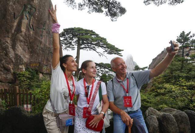 (250509) -- HUANGSHAN, May 9, 2025 (Xinhua) -- Foreign tourists take selfies in front of the Guest-Greeting Pine, an iconic landmark of Huangshan Mountain, in east China's Anhui Province, on Sept. 12, 2024. Huangshan Mountain is a listed UNESCO World Cultural and Natural Heritage Site, which has attracted a large number of tourists.
  To minimize the impact of visitors on its vegetation growth, the Huangshan Scenic Area rotates days off for its major scenic spots, as a special arrangement for ecological protection.
   The Tiandu Peak, one of the most popular sites in the Huangshan scenic area, ended its more than five-year "vacation" and resumed opening to the public on May 20, 2024. While the Lianhua Peak, the highest peak of Huangshan Mountain, has been so far closed for more than a year. (Photo by Shi Yalei/Xinhua)