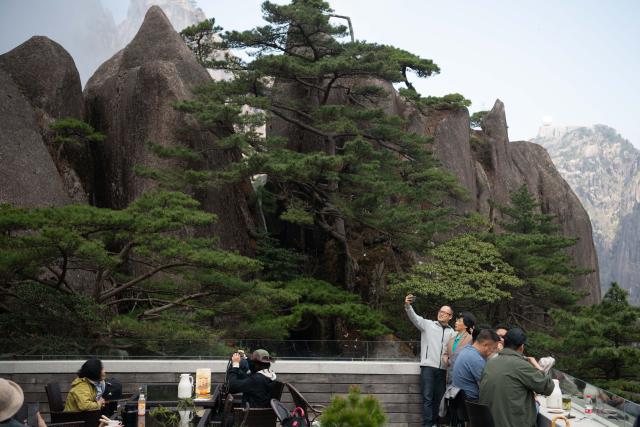(250509) -- HUANGSHAN, May 9, 2025 (Xinhua) -- Tourists enjoy the view of Huangshan Scenic Area in east China's Anhui Province, on April 23, 2025. Huangshan Mountain is a listed UNESCO World Cultural and Natural Heritage Site, which has attracted a large number of tourists.
  To minimize the impact of visitors on its vegetation growth, the Huangshan Scenic Area rotates days off for its major scenic spots, as a special arrangement for ecological protection.
   The Tiandu Peak, one of the most popular sites in the Huangshan scenic area, ended its more than five-year "vacation" and resumed opening to the public on May 20, 2024. While the Lianhua Peak, the highest peak of Huangshan Mountain, has been so far closed for more than a year. (Xinhua/Zhang Duan)