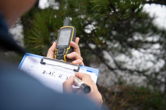 (250509) -- HUANGSHAN, May 9, 2025 (Xinhua) -- Wu Yijun, a senior engineer of the parks and woods bureau of Huangshan Scenic Area management committee, keeps record of plant location at Lianhua Peak of Huangshan in east China's Anhui Province, on April 22, 2025. Huangshan Mountain is a listed UNESCO World Cultural and Natural Heritage Site, which has attracted a large number of tourists.
  To minimize the impact of visitors on its vegetation growth, the Huangshan Scenic Area rotates days off for its major scenic spots, as a special arrangement for ecological protection.
   The Tiandu Peak, one of the most popular sites in the Huangshan scenic area, ended its more than five-year "vacation" and resumed opening to the public on May 20, 2024. While the Lianhua Peak, the highest peak of Huangshan Mountain, has been so far closed for more than a year. (Xinhua/Zhang Duan)