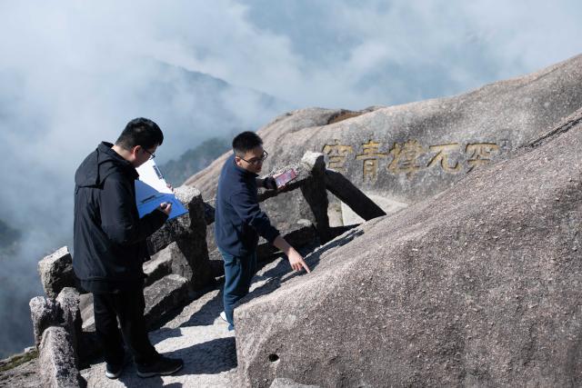 (250509) -- HUANGSHAN, May 9, 2025 (Xinhua) -- Staff workers of Huangshan Scenic Area Yu Yangyang and Sheng Zeyang (L) conduct inspection on historical stone carvings at Lianhua Peak of Huangshan in east China's Anhui Province, on April 23, 2025. Huangshan Mountain is a listed UNESCO World Cultural and Natural Heritage Site, which has attracted a large number of tourists.
  To minimize the impact of visitors on its vegetation growth, the Huangshan Scenic Area rotates days off for its major scenic spots, as a special arrangement for ecological protection.
   The Tiandu Peak, one of the most popular sites in the Huangshan scenic area, ended its more than five-year "vacation" and resumed opening to the public on May 20, 2024. While the Lianhua Peak, the highest peak of Huangshan Mountain, has been so far closed for more than a year. (Xinhua/Zhang Duan)