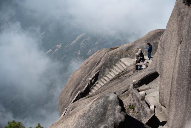 (250509) -- HUANGSHAN, May 9, 2025 (Xinhua) -- A staff worker conducts inspection at Lianhua Peak of Huangshan in east China's Anhui Province, on April 23, 2025. Huangshan Mountain is a listed UNESCO World Cultural and Natural Heritage Site, which has attracted a large number of tourists.
  To minimize the impact of visitors on its vegetation growth, the Huangshan Scenic Area rotates days off for its major scenic spots, as a special arrangement for ecological protection.
   The Tiandu Peak, one of the most popular sites in the Huangshan scenic area, ended its more than five-year "vacation" and resumed opening to the public on May 20, 2024. While the Lianhua Peak, the highest peak of Huangshan Mountain, has been so far closed for more than a year. (Xinhua/Zhang Duan)