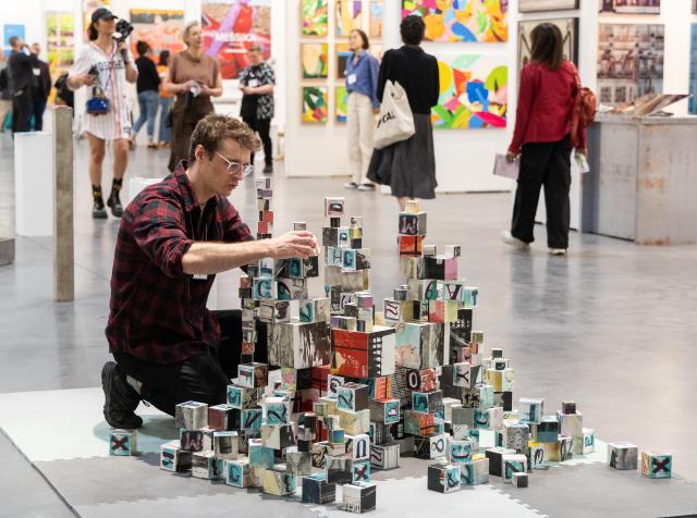 (250509) -- TORONTO, May 9, 2025 (Xinhua) -- An artist arranges his works during the 2025 Artist Project event in Toronto, Canada, on May 9, 2025. Showcasing thousands of artworks and installations from over 250 independent artists, the annual event is held here from May 8 to May 11. (Photo by Zou Zheng/Xinhua)