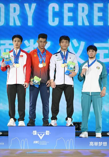 (250510) -- JIANGSHAN, May 10, 2025 (Xinhua) -- Total gold medalist Tran Minh Tri (2nd L) of Vietnam, silver medalist Zheng Xinhao (1st L) of China, bronze medalist Bae Moonsu (2nd R) of South Korea and bronze medalist for snatch Khusinboy Matrasulov of Uzbekistan pose during the awarding ceremony for the men's 67kg competition at 2025 Asian Weightlifting Championships in Jiangshan, east China's Zhejiang Province, May 10, 2025. (Xinhua/Hou Zhaokang)