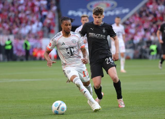(250511) -- MUNICH, May 11, 2025 (Xinhua) -- Bayern Munich's Michael Olise (L) vies with Moenchengladbach's Lukas Ullrich during the German first division Bundesliga football match between Bayern Munich and Borussia Moenchengladbach in Munich, Germany, May 10, 2025. (Photo by Philippe Ruiz/Xinhua)