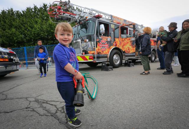 (250511) -- RICHMOND, May 11, 2025 (Xinhua) -- A boy poses for photos in front of a fire truck during the Public Works Open House event in Richmond, British Columbia, Canada, May 10, 2025. Featuring interactive exhibits, equipment displays and more, the one-day event offered a behind-the-scenes look at the essential services that keep the city running smoothly. (Photo by Liang Sen/Xinhua)