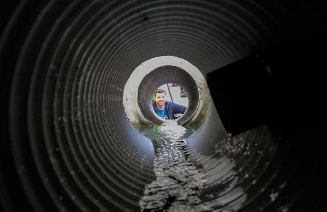 (250511) -- RICHMOND, May 11, 2025 (Xinhua) -- A man looks inside a sewage pipe during the Public Works Open House event in Richmond, British Columbia, Canada, May 10, 2025. Featuring interactive exhibits, equipment displays and more, the one-day event offered a behind-the-scenes look at the essential services that keep the city running smoothly. (Photo by Liang Sen/Xinhua)