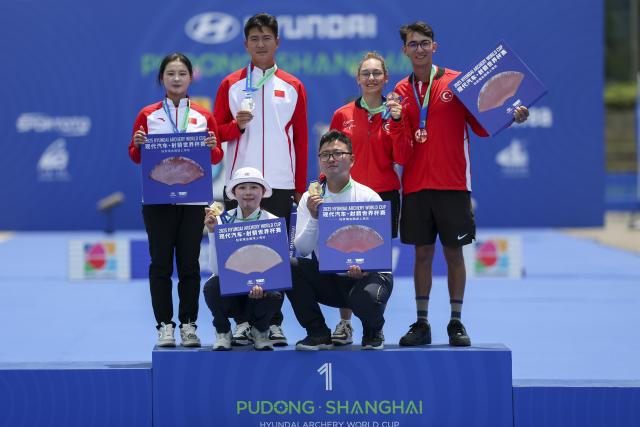(250511) -- SHANGHAI, May 11, 2025 (Xinhua) -- Gold medalists team South Korea (bottom), silver medalists team China (top L) and bronze medalists team Türkiye pose during the awarding ceremony for the Recurve Mixed Team competition at Shanghai 2025 Archery World Cup Stage 2 in Shanghai, east China, May 11, 2025. (Xinhua/Wang Xiang)
