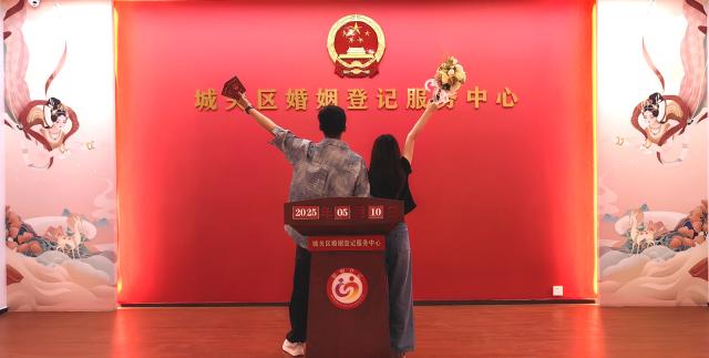 (250511) -- BEIJING, May 11, 2025 (Xinhua) -- A couple poses for photos with their marriage certificates at a marriage registration office in Chengguan District of Lanzhou, northwest China's Gansu Province, May 10, 2025. (Gansu provincial civil affairs department/Handout via Xinhua)