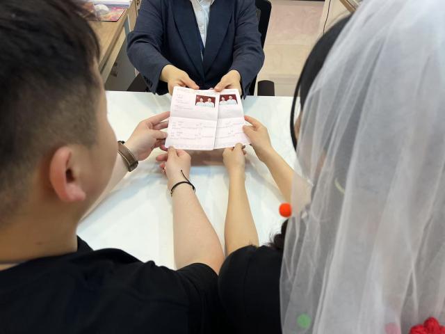 (250511) -- BEIJING, May 11, 2025 (Xinhua) -- A couple receives their marriage certificates at a marriage registration office in Chengguan District of Lanzhou, northwest China's Gansu Province, May 10, 2025. (Gansu provincial civil affairs department/Handout via Xinhua)