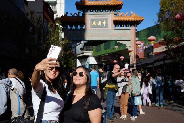 (250511) -- BUENOS AIRES, May 11, 2025 (Xinhua) -- People pose for selfies in front of the archway of the Chinatown in Buenos Aires, Argentina, May 10, 2025. In 2009, the archway of the Chinatown in Buenos Aires was officially completed. Nowadays, the Chinatown has become an important tourist attraction in the local area, attracting many people to experience the charm of Eastern culture. (Xinhua/Meng Dingbo)