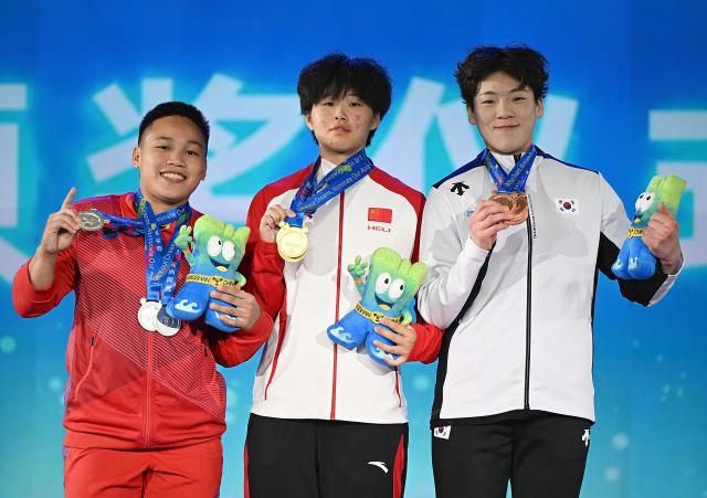 (250511) -- JIANGSHAN, May 11, 2025 (Xinhua) -- Total gold medalist Li Shuang of China (C), silver medalist Elreen Ann Ando (L) of the Philippines and bronze medalist Mun Minhee of South Korea pose during the awarding ceremony for the women's 64kg competition at 2025 Asian Weightlifting Championships in Jiangshan, east China's Zhejiang Province, May 11, 2025. (Xinhua/Hou Zhaokang)