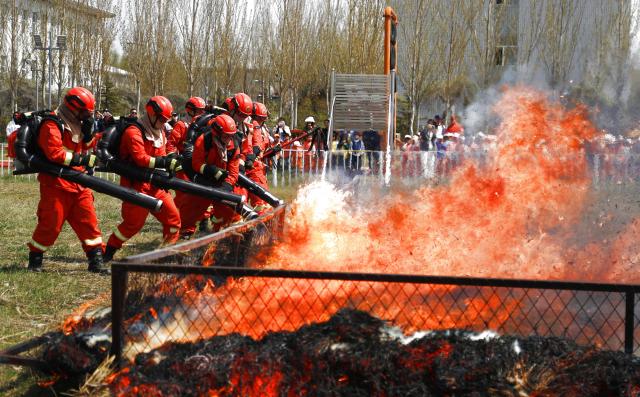 (250511) -- BEIJING, May 11, 2025 (Xinhua) -- Firefighters demonstrate team-based firefighting operations to the public in Daqing City, northeast China's Heilongjiang Province, May 9, 2025. China observes the National Disaster Prevention and Reduction Day on May 12 each year. Various publicity, drill and training activities are carried out across China to improve public awareness in scientific disaster prevention and self-rescue. (Photo by Xue Gang/Xinhua)
