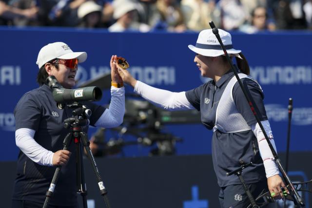 (250511) -- SHANGHAI, May 11, 2025 (Xinhua) -- Lee Gahyun (R) of South Korea high-fives with her coach during the gold final of the Recurve Women's competition at Shanghai 2025 Archery World Cup Stage 2 in Shanghai, east China, May 11, 2025. (Xinhua/Wang Xiang)