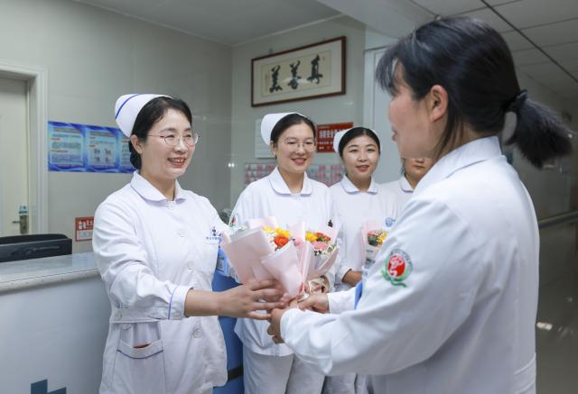 (250511) -- ZAOZHUANG, May 11, 2025 (Xinhua) -- A doctor presents flowers to a nurse at a mental health center in Zaozhuang, east China's Shandong Province, May 10, 2025. International Nurses Day, which falls annually on May 12, have recently been observed across China in various forms. (Photo by Wang Longfei/Xinhua)