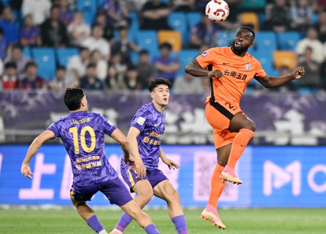 (250511) -- TIANJIN, May 11, 2025 (Xinhua) -- Oscar Taty Maritu (top) of Yunnan Yukun competes during the 12nd round match between Tianjin Jinmen Tiger and Yunnan Yukun at the 2025 season Chinese Football Super League (CSL) in north China's Tianjin, May 11, 2025. (Xinhua/Zhao Zishuo)