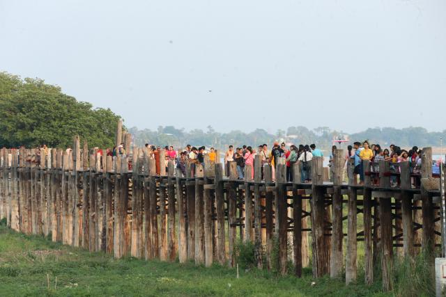 (250512) -- MANDALAY, May 12, 2025 (Xinhua) -- People walk on the U Bein Bridge in Mandalay, Myanmar, May 11, 2025. (Xinhua/Myo Kyaw Soe)