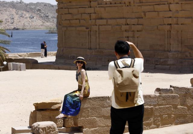 (250512) -- CAIRO, May 12, 2025 (Xinhua) -- A tourist poses for photos at the Philae Temple complex by the Nile River in Aswan, Egypt, May 3, 2025.
  TO GO WITH "Feature: Egypt's cultural south charms tourists worldwide" (Xinhua/Ahmed Gomaa)