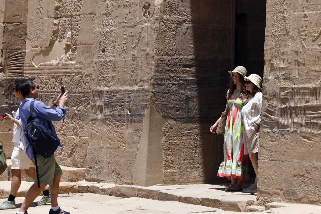 (250512) -- CAIRO, May 12, 2025 (Xinhua) -- Tourists pose for photos at the Philae Temple complex by the Nile River in Aswan, Egypt, May 3, 2025.
  TO GO WITH "Feature: Egypt's cultural south charms tourists worldwide" (Xinhua/Ahmed Gomaa)